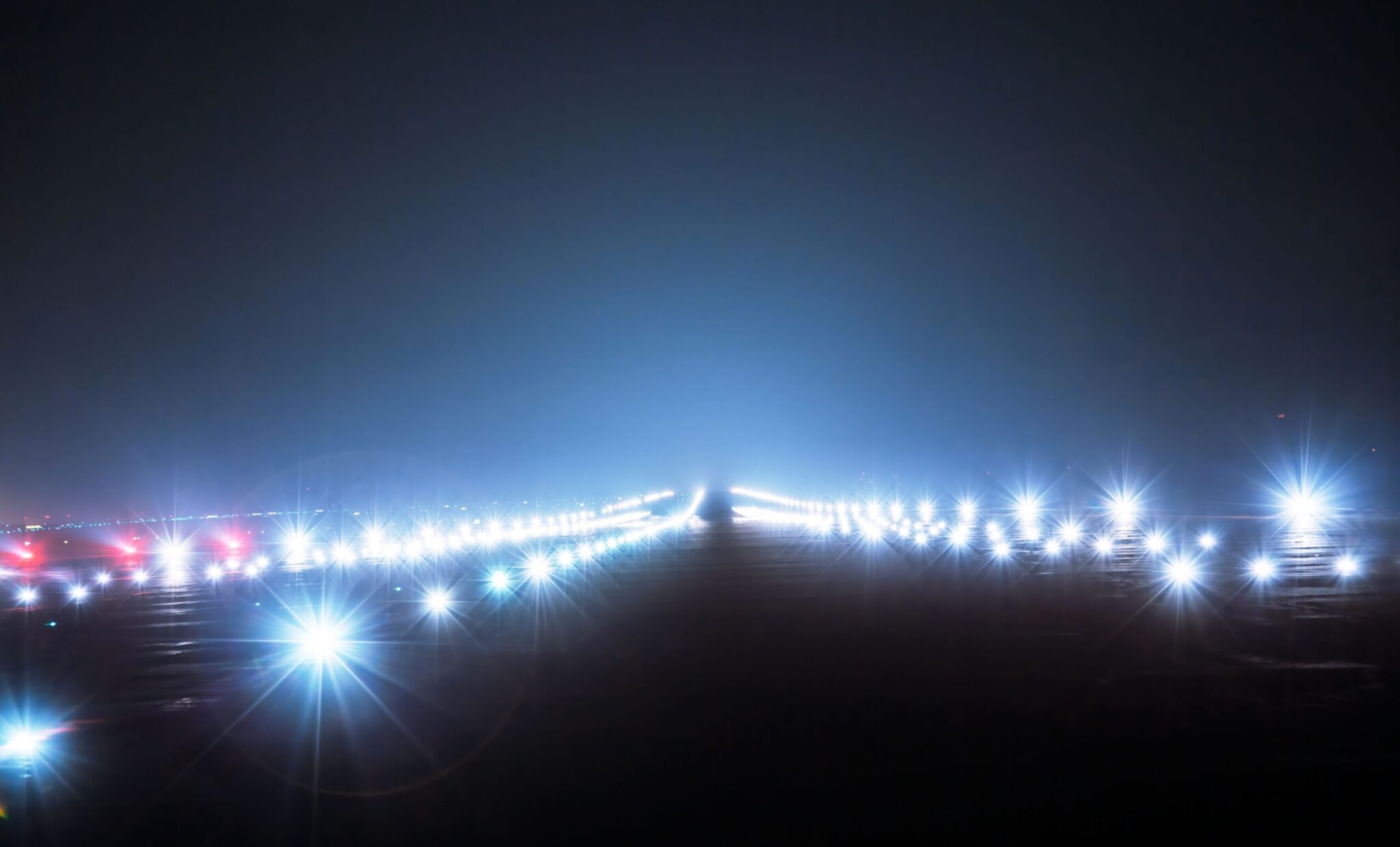 The cover of the ACI Annual Report 2019 features a brightly lit airport runway at night, with blue and white lights lining both sides to create a glowing path that stretches into the distance.