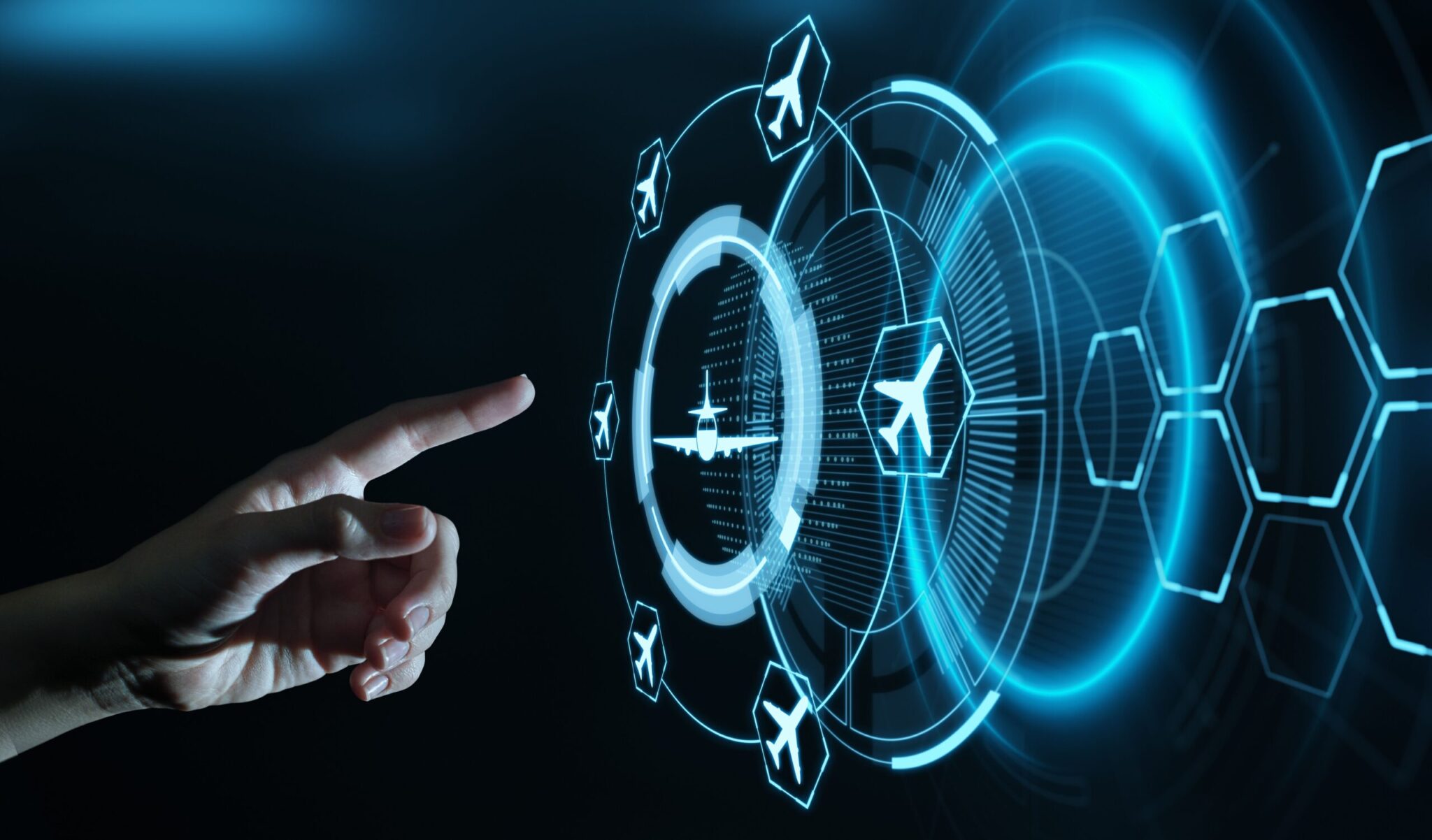 A hand points to a digital interface with glowing airplane icons and futuristic graphics, representing the 