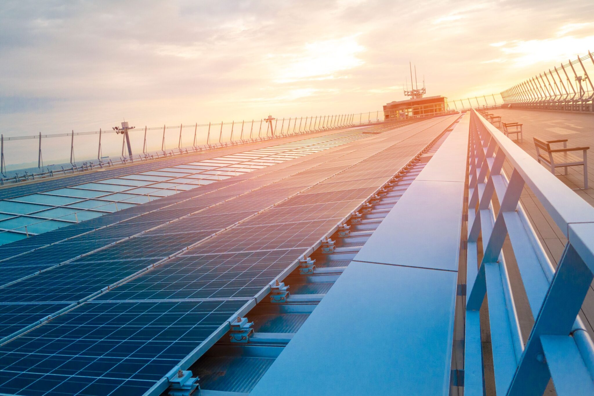 Rows of solar panels on a rooftop reflect sunlight, illustrating the 