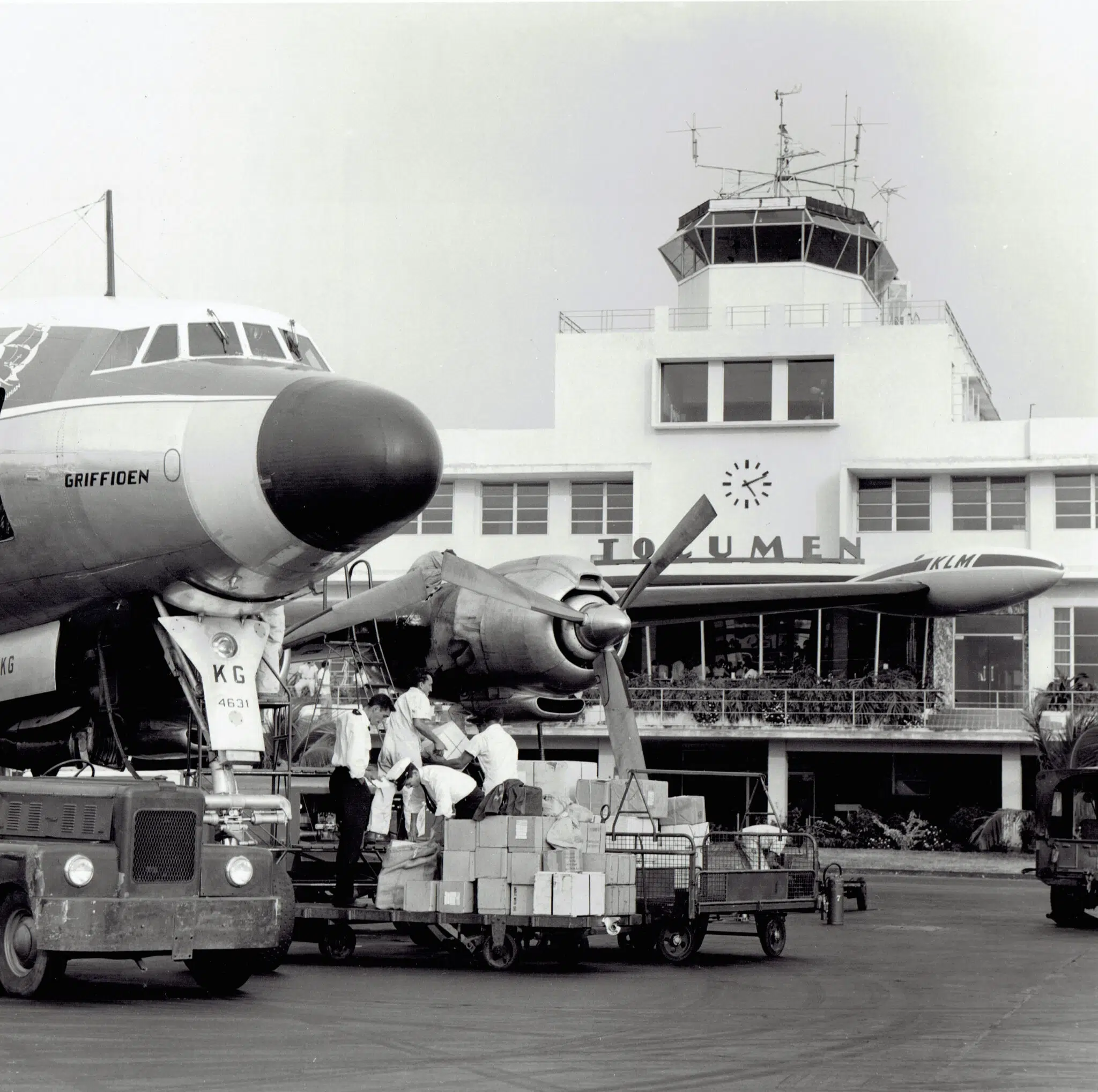 Black and white photo of workers loading cargo onto a vintage plane at Tocumen Airport’s main terminal—an iconic moment from 
